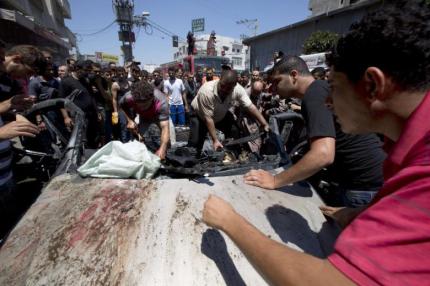 People gather around a vehicle targeted in an Israeli airstrike on Gaza City on July 8, 2014 that killed four Palestinians. (Photo: AFP - Mohammed Abed) http://english.al-akhbar.com/content/israeli-war-jets-bomb-50-sites-gaza